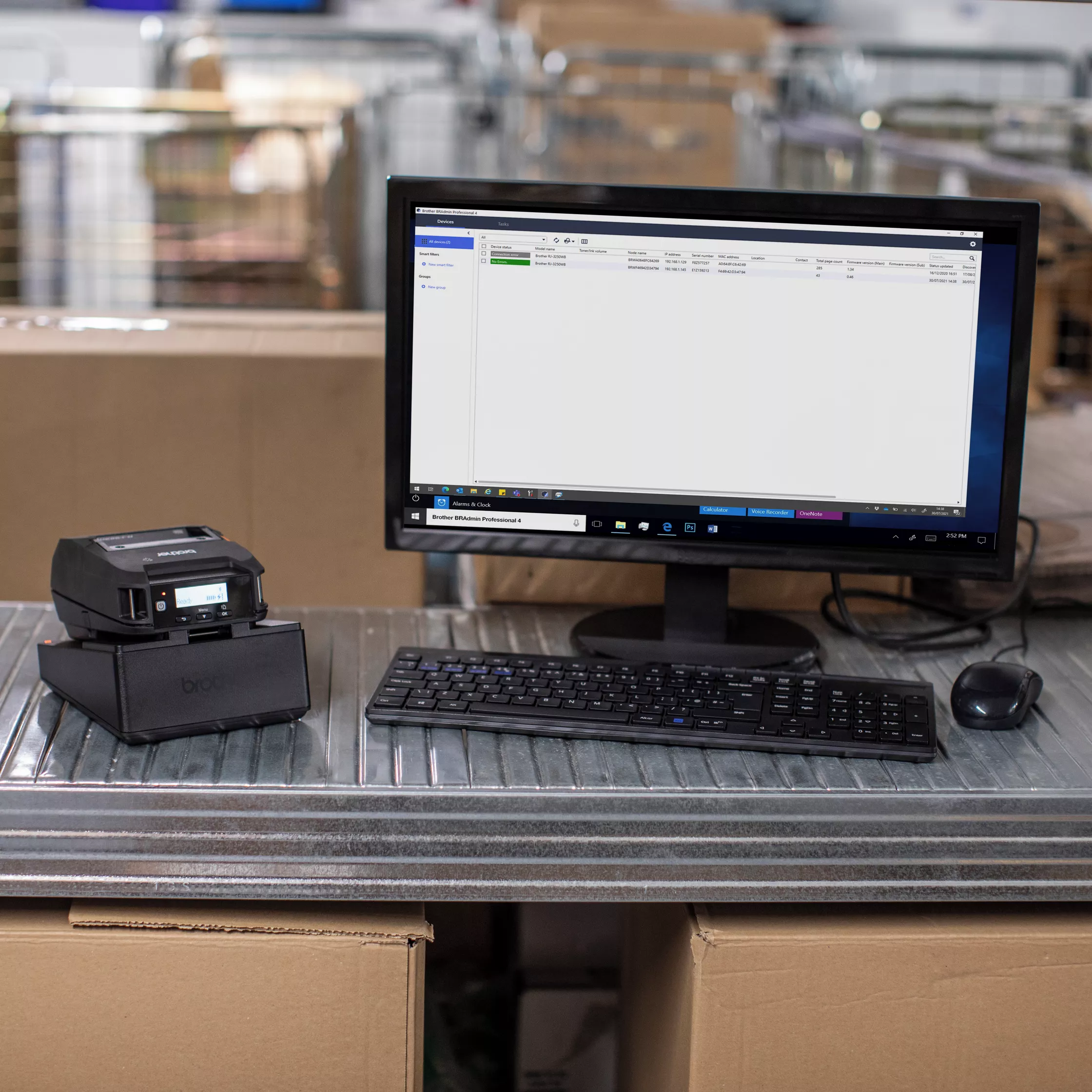 portable printer brother rj-3230b in charging cradle next to desktop computer