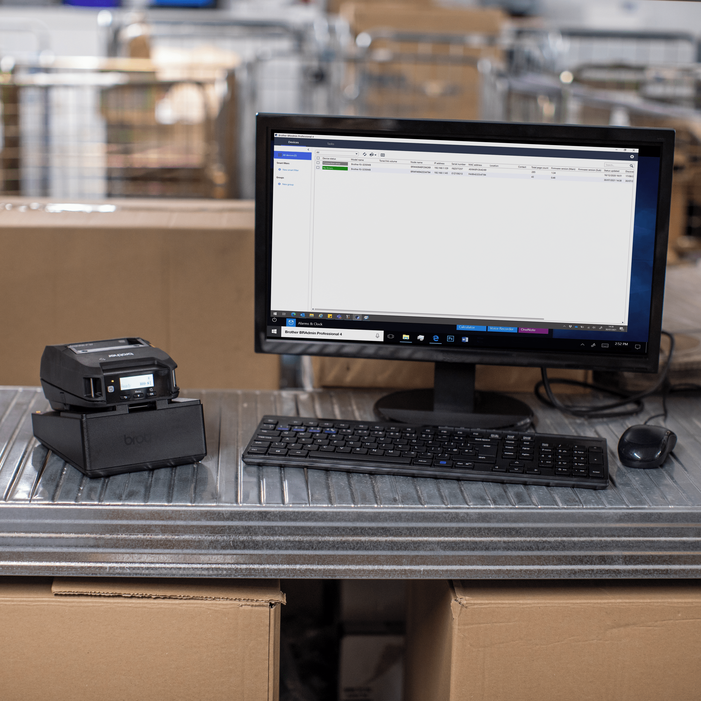 portable printer brother rj-3250wb in charging cradle next to desktop computer